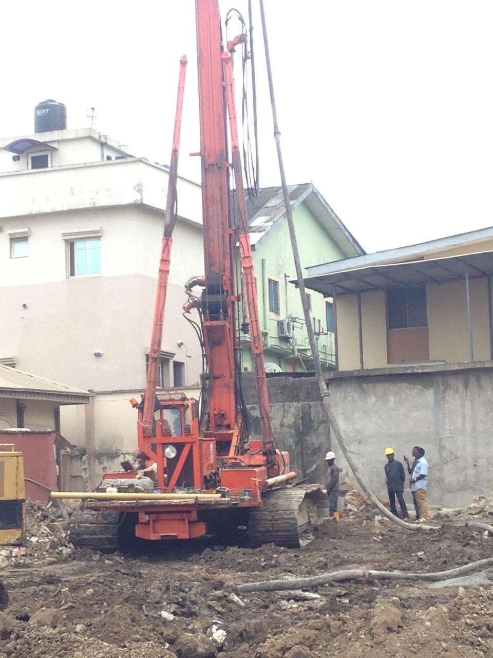 Rotary bored piling rig working between buildings on a tight urban plot