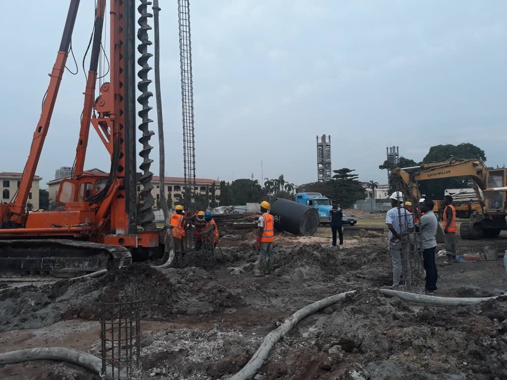 Rotary bored piling rig and crew installing reinforcement cages on a city-centre site