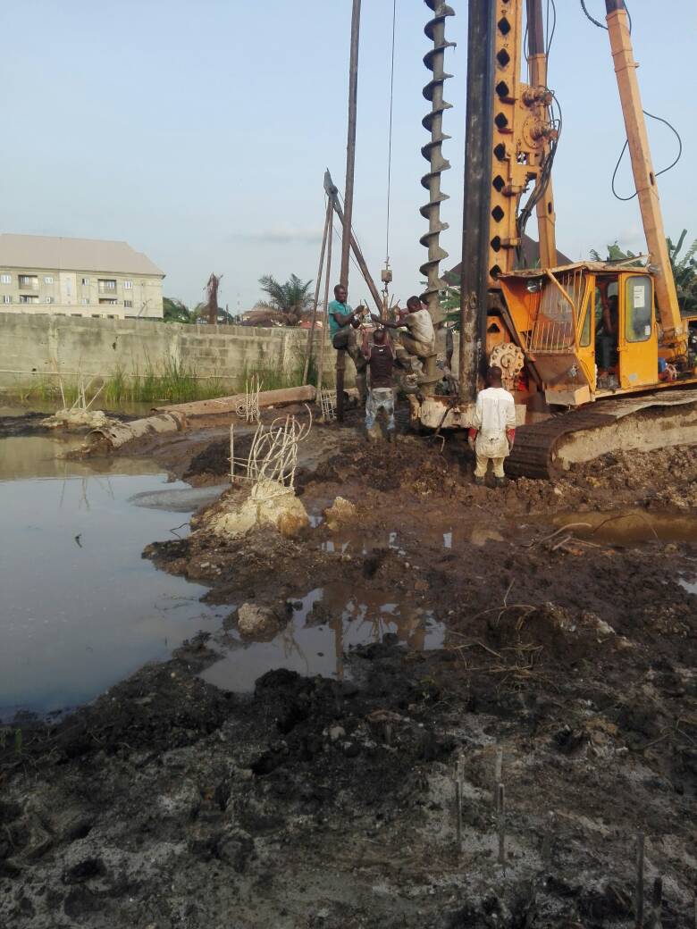 CFA auger piling rig working on waterlogged ground beside standing water